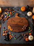 Tabla Jack-o’-lantern sirviendo dulces de Halloween sobre una base de pizarra